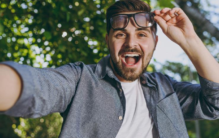 joven levanta sus lentes y disfruta de su cirugia de ojos