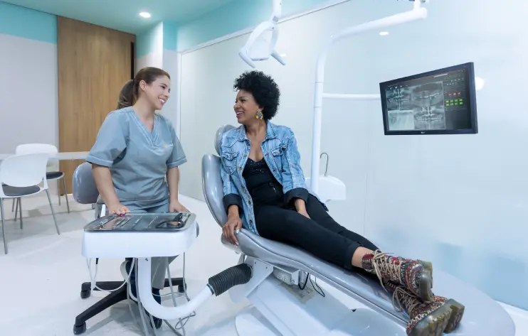 paciente y doctora se miran felices tras tratamiento odontologico