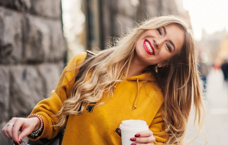 mujer con diseno de sonrisa sosteniendo un cafe
