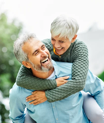 pareja de adultos mayores felices con sus implantes dentales