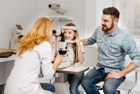 papa acompanando a hija en examen de oftalmologia pediatrica