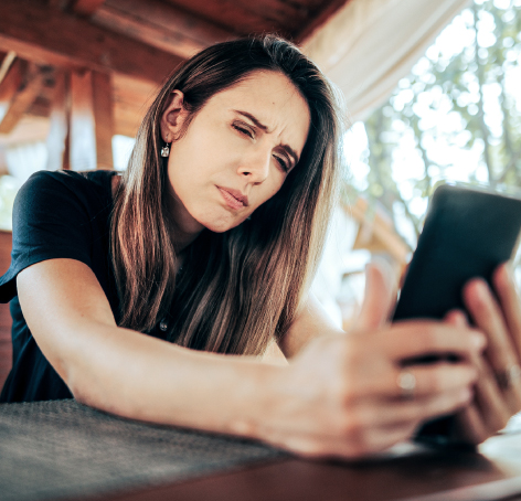 mujer con dificultad para mirar su celular