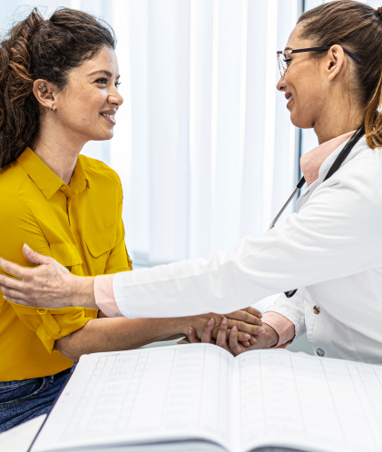 doctora estrechando la mano de paciente mujer