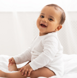 bebe de 12 meses sentado en una cama