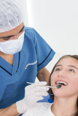 odontologa revisando los dientes de una joven