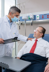 doctor habla con paciente mientras toca su hombro