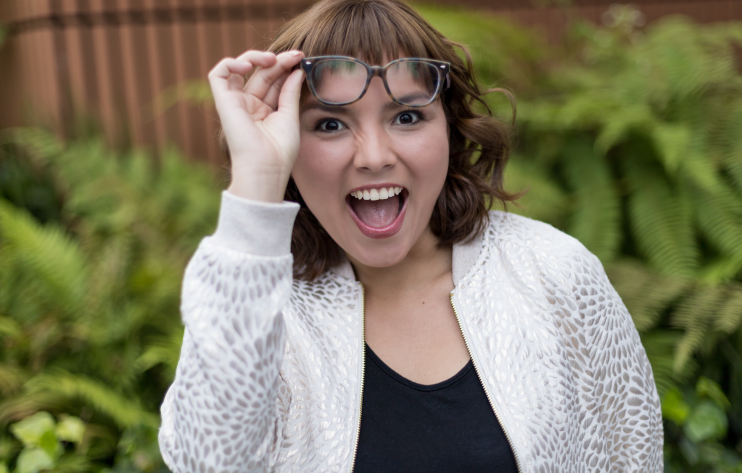 mujer sonriente levantando sus lentes