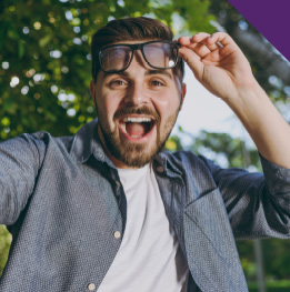 joven levanta sus lentes y disfruta de su cirugia de ojos
