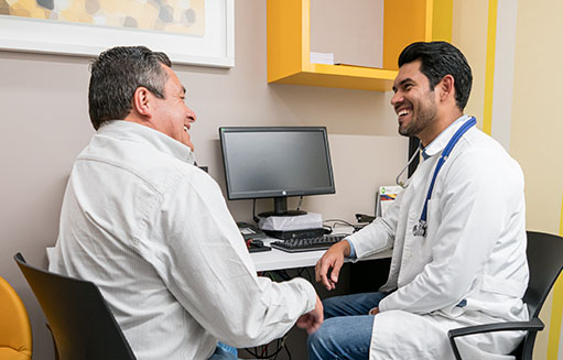 doctor sonriendo con paciente en consultorio medico