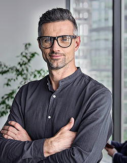 hombre de gafas con los brazos cruzados