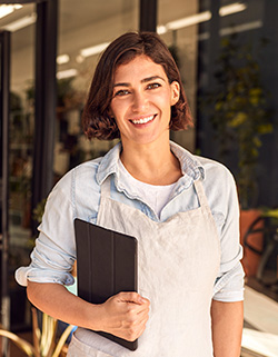 mujer sonriendo sosteniendo una tablet