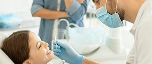 odontologo revisando dientes de nina