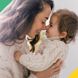 mama cargando feliz a su bebe de 18 meses
