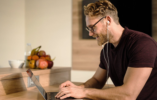 hombre con audifonos leyendo sobre el chequeo vital en portatil