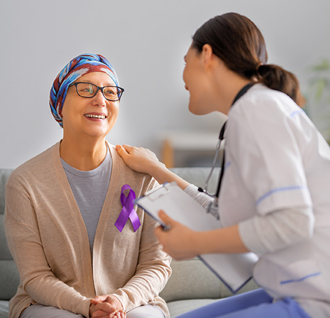 doctora tocando el hombro de paciente oncologica