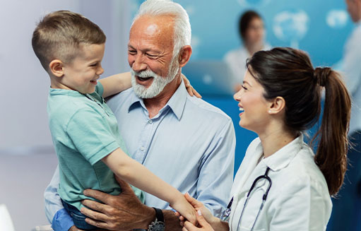 doctora sonriendo con abuelo y su nieto