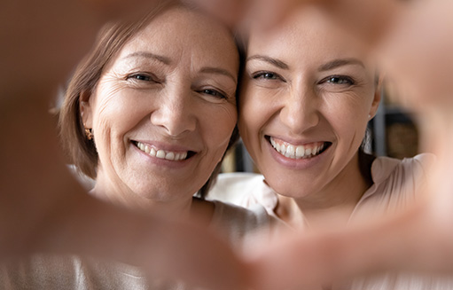 mama e hija haciendo simbolo de corazon