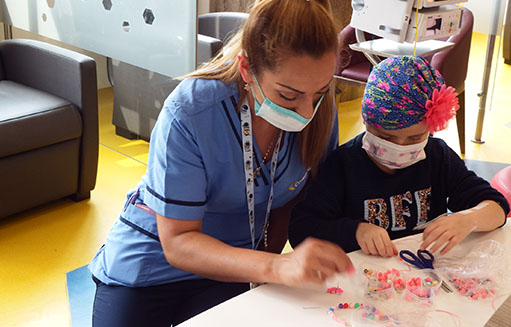 doctora jugando con nina con cancer pediatrico