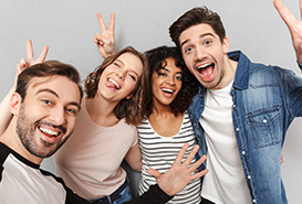 4 jovenes felices saludando a la camara